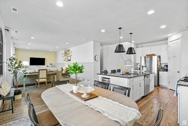 dining space with light wood finished floors and recessed lighting
