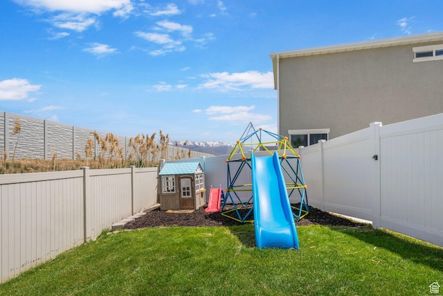 view of yard with a playground, a storage unit, and an outbuilding