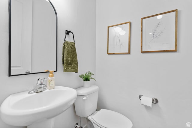 half bathroom featuring a sink and toilet