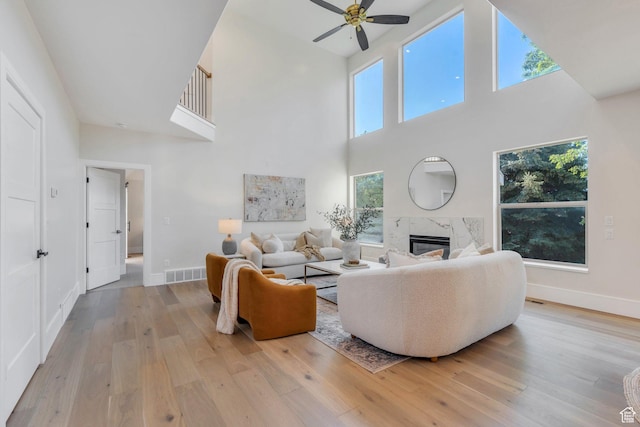 1309 W 1870 N, Provo, UT 84604 - living room with a ceiling fan, a high ceiling, a premium fireplace, light wood finished floors, and baseboards
