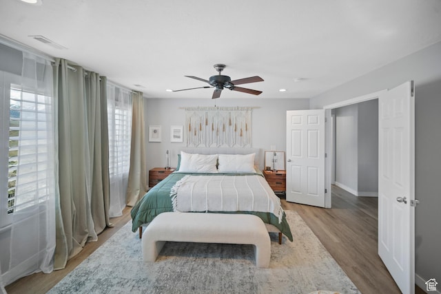bedroom featuring wood finished floors, a ceiling fan, recessed lighting, and baseboards
