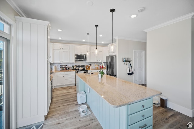 kitchen featuring appliances with stainless steel finishes, a sink, ornamental molding, backsplash, and white cabinetry