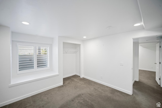 unfurnished bedroom featuring dark carpet, baseboards, recessed lighting, and a closet