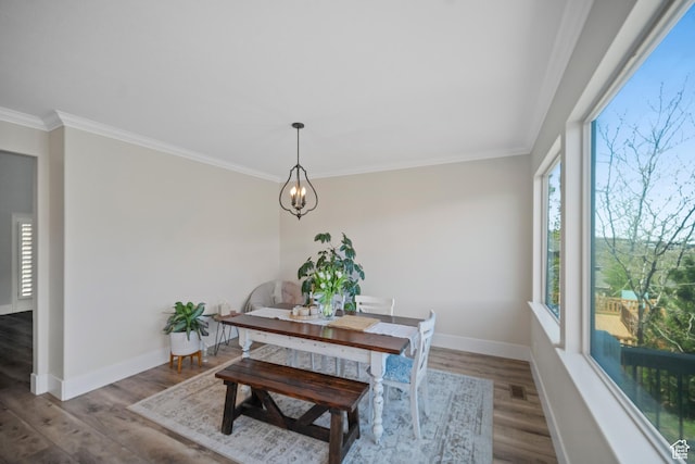 dining space featuring ornamental molding, wood finished floors, baseboards, and a chandelier