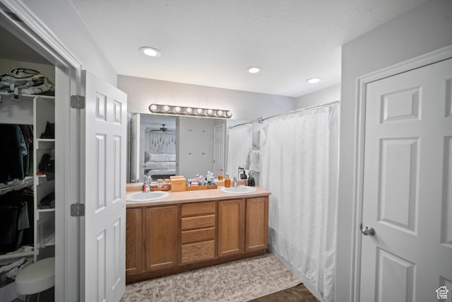 bathroom featuring double vanity, a spacious closet, connected bathroom, curtained shower, and recessed lighting