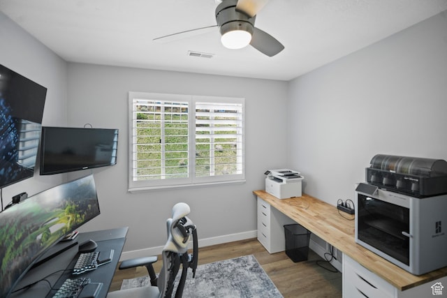 office area with wood finished floors, a ceiling fan, and baseboards