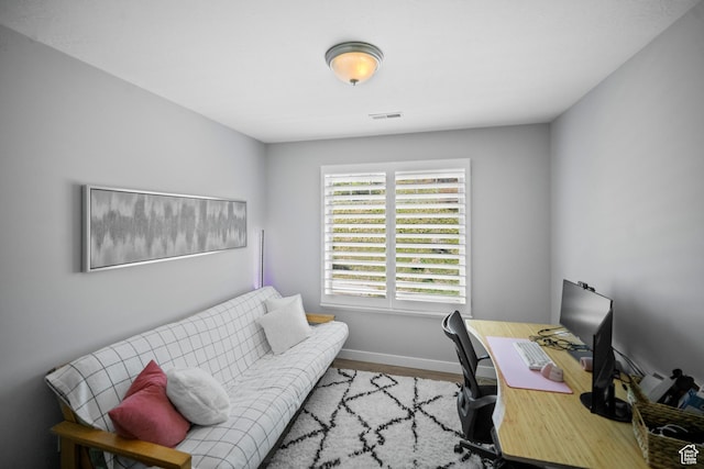 home office with baseboards and wood finished floors