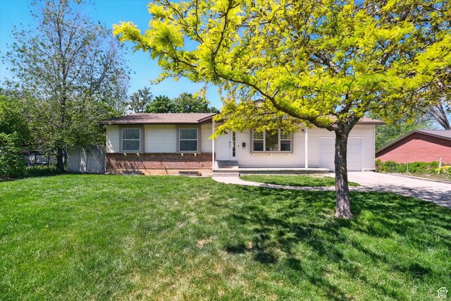 621 N 300 E, Brigham City, UT 84302 - view of front of property featuring brick siding, an attached garage, and concrete driveway