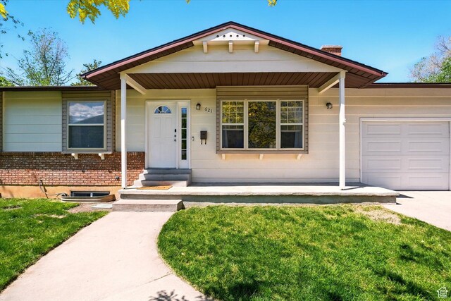 621 N 300 E, Brigham City, UT 84302 - single story home with an attached garage, brick siding, a front yard, and a chimney