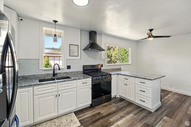 621 N 300 E, Brigham City, UT 84302 - kitchen featuring gas range, wall chimney range hood, a sink, freestanding refrigerator, and a peninsula