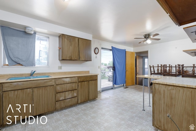 kitchen featuring a sink, light floors, light countertops, and a ceiling fan