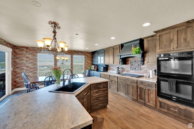 1341 S Sageberry Dr, Santaquin, UT 84655 - kitchen featuring a sink, custom range hood, a chandelier, light wood-style flooring, and light countertops