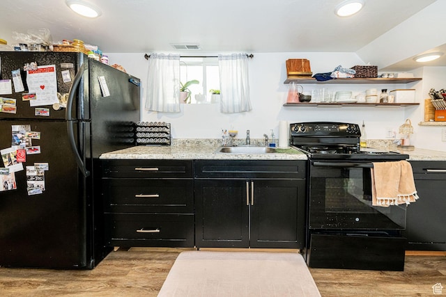 141 W 400 N, Logan, UT 84321 - kitchen with black appliances, dark cabinetry, a sink, and light wood-style floors