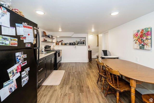 141 W 400 N, Logan, UT 84321 - kitchen with black appliances, light wood finished floors, light countertops, dark cabinets, and open shelves