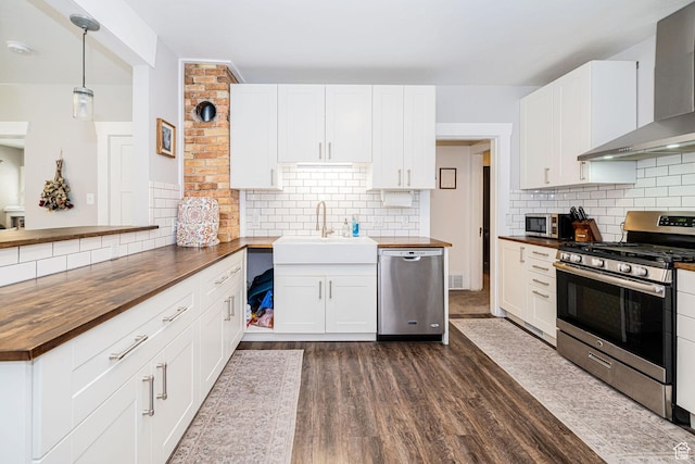 141 W 400 N, Logan, UT 84321 - kitchen featuring butcher block countertops, stainless steel appliances, wall chimney exhaust hood, a sink, and decorative backsplash