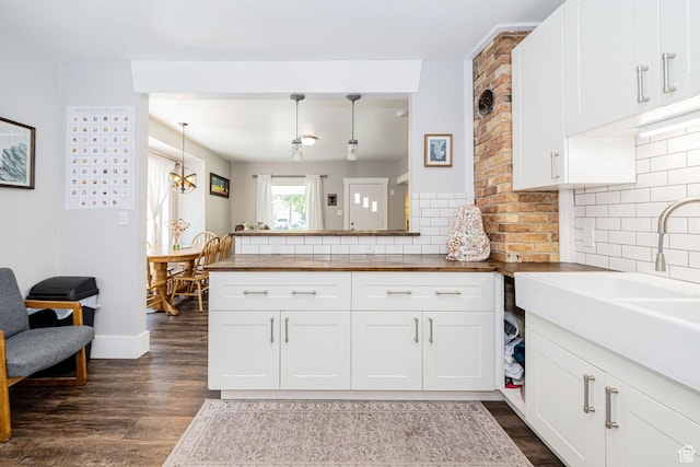 141 W 400 N, Logan, UT 84321 - kitchen with wooden counters, dark wood-style flooring, tasteful backsplash, and white cabinetry