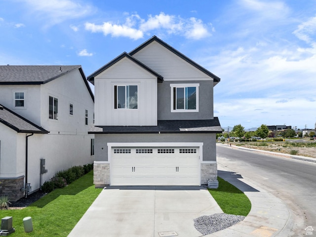 295 N 1580 W Unit 101, Pleasant Grove, UT 84062 - view of front of home with stone siding, concrete driveway, a garage, and a front lawn