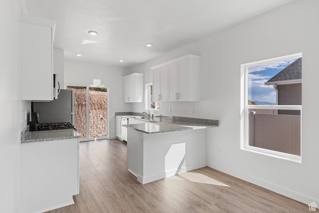 7308 Bald Eagle Way N, Eagle Mountain, UT 84005 - kitchen with light wood-style floors, white cabinets, baseboards, freestanding refrigerator, and recessed lighting