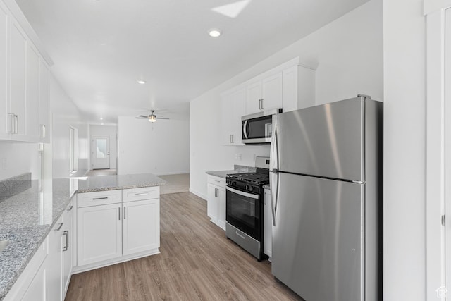 7308 Bald Eagle Way N, Eagle Mountain, UT 84005 - kitchen with appliances with stainless steel finishes, white cabinets, a peninsula, light wood finished floors, and recessed lighting