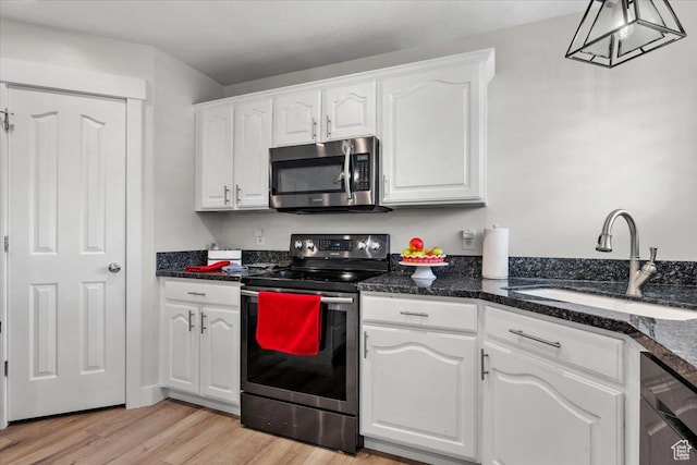 10539 S Haven View Ct W, South Jordan, UT 84095 - kitchen featuring appliances with stainless steel finishes, a sink, white cabinetry, light wood finished floors, and dark stone counters
