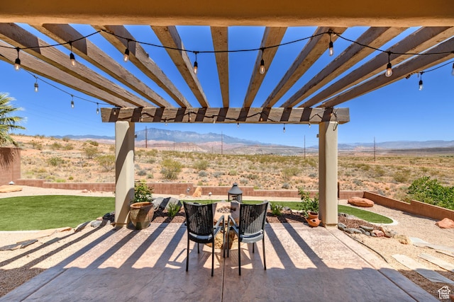 view of patio / terrace featuring a mountain view, a pergola, and view of desert landscape