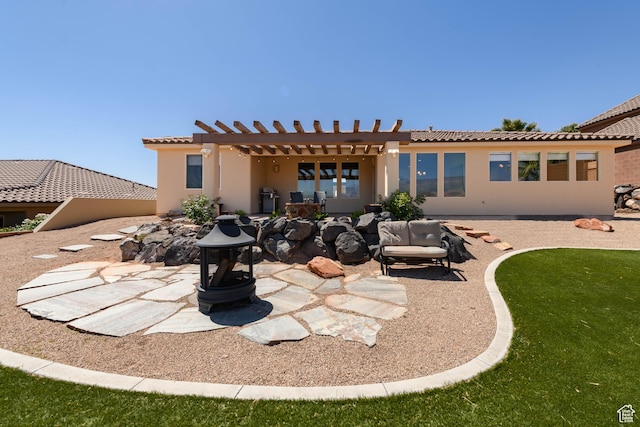 back of house with a tile roof, a pergola, a patio, and stucco siding