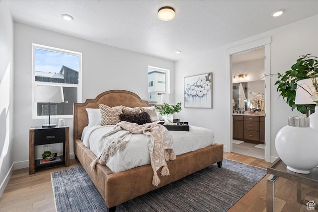 bedroom with light wood finished floors, recessed lighting, connected bathroom, and baseboards