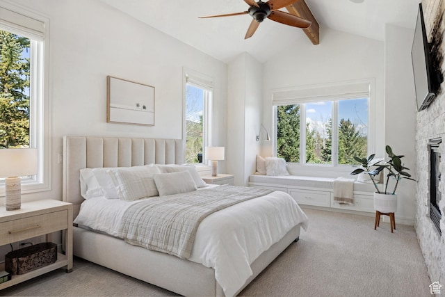 bedroom featuring a fireplace, light colored carpet, and a ceiling fan