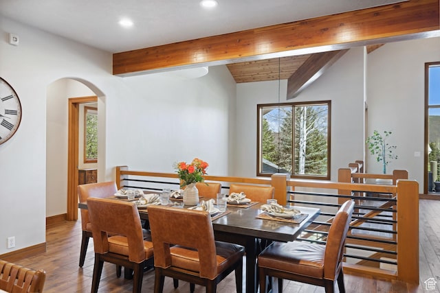 dining room with wood-type flooring, recessed lighting, arched walkways, and baseboards