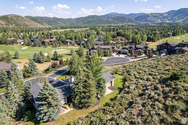 aerial view of property and surrounding area featuring a mountainous background, nearby suburban area, and a golf club