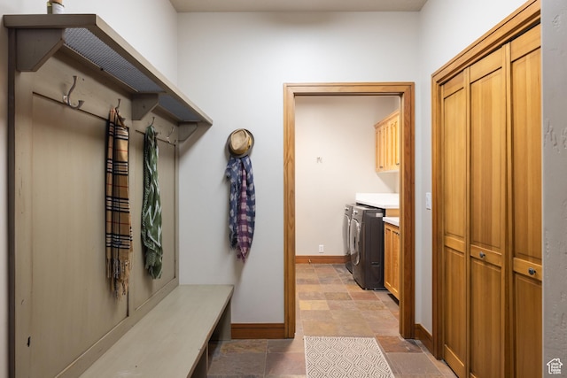 mudroom with baseboards, light stone finish flooring, and separate washer and dryer