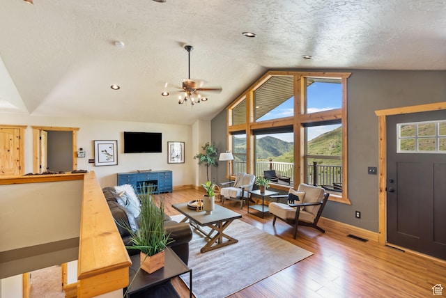 2013 N River View Cir, Huntsville, UT 84317 - living room featuring lofted ceiling, a textured ceiling, baseboards, healthy amount of natural light, and wood finished floors