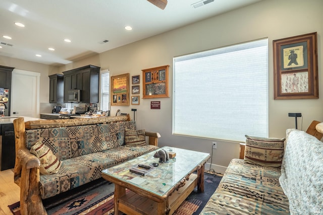 living area featuring recessed lighting, plenty of natural light, and baseboards