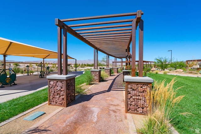 view of property's community featuring a pergola, a mountain view, and a yard