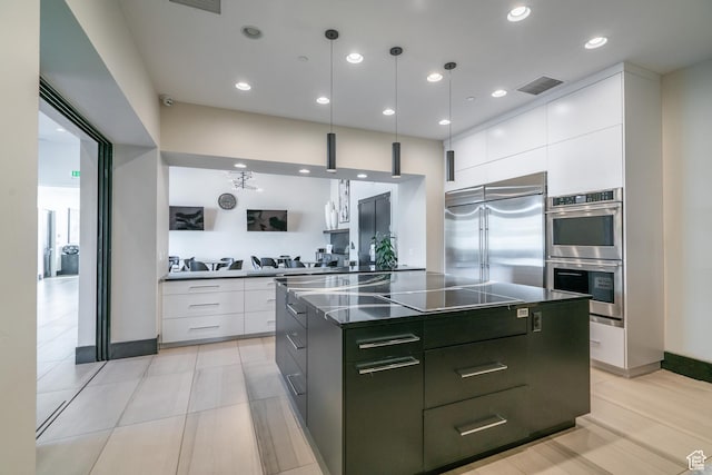 kitchen featuring appliances with stainless steel finishes, dark countertops, modern cabinets, white cabinetry, and a kitchen island