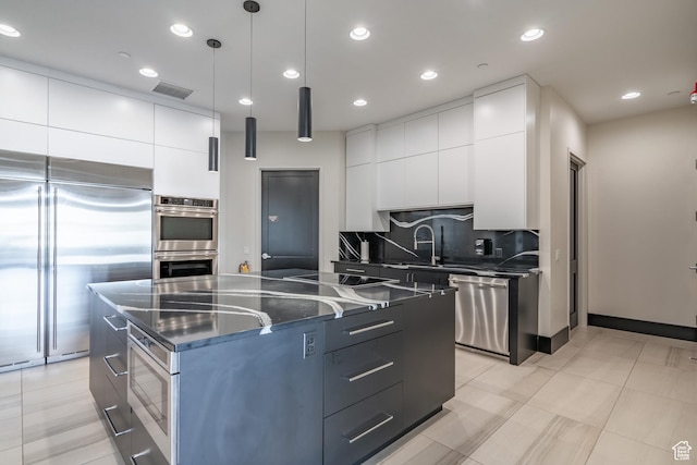 kitchen featuring built in appliances, modern cabinets, backsplash, a kitchen island, and recessed lighting