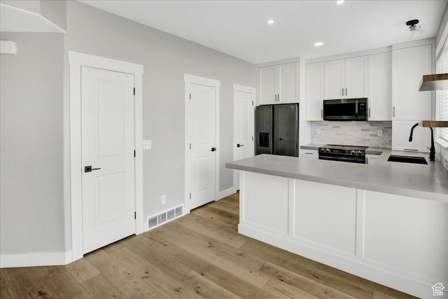91 E 8000 S, Midvale, UT 84070 - kitchen with black appliances, a sink, decorative backsplash, white cabinets, and light countertops