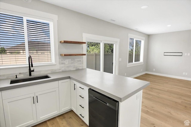 91 E 8000 S, Midvale, UT 84070 - kitchen featuring a sink, a peninsula, light wood-style floors, white cabinets, and backsplash
