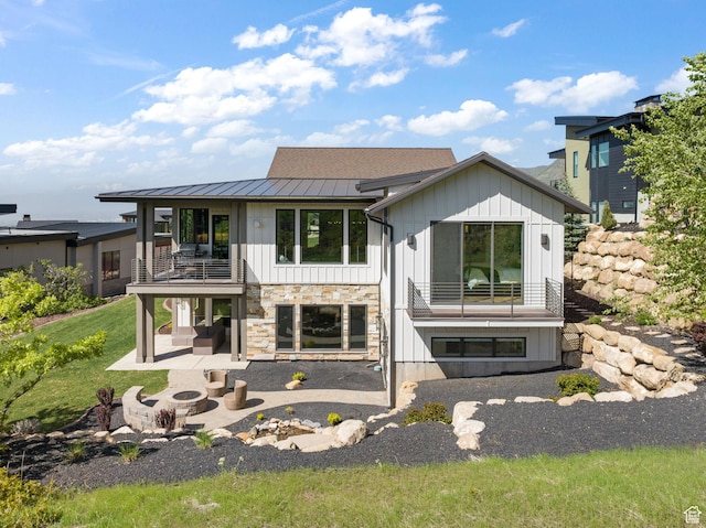 732 S Nebo Cir, Woodland Hills, UT 84653 - back of house with a balcony, an outdoor fire pit, a standing seam roof, a patio area, and board and batten siding