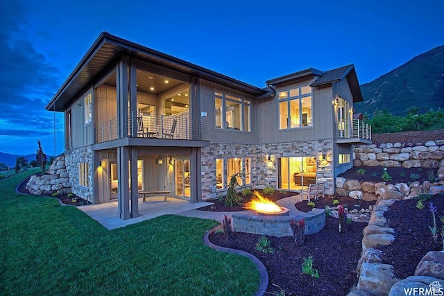 732 S Nebo Cir, Woodland Hills, UT 84653 - rear view of house featuring a balcony, stone siding, a patio, and a yard