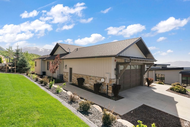 732 S Nebo Cir, Woodland Hills, UT 84653 - view of property exterior featuring driveway, stone siding, a garage, a mountain view, and a yard