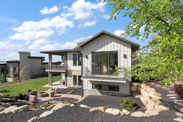 732 S Nebo Cir, Woodland Hills, UT 84653 - rear view of house featuring board and batten siding, an outdoor fire pit, stone siding, a patio area, and a balcony