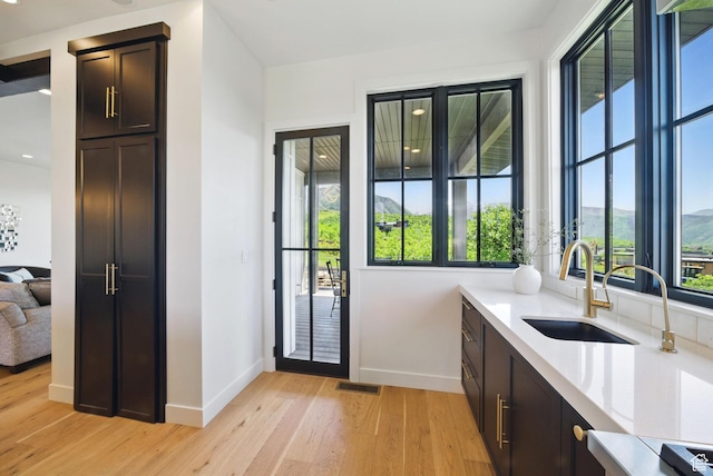 732 S Nebo Cir, Woodland Hills, UT 84653 - doorway featuring a sink, baseboards, and light wood finished floors