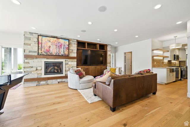 732 S Nebo Cir, Woodland Hills, UT 84653 - living area featuring light wood finished floors, a stone fireplace, and recessed lighting