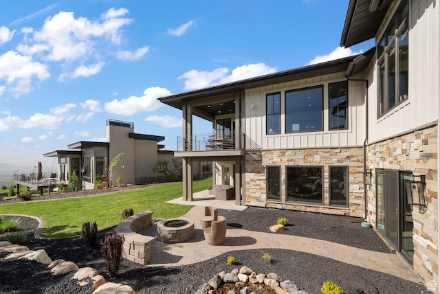 732 S Nebo Cir, Woodland Hills, UT 84653 - back of house with a balcony, stone siding, a fire pit, a lawn, and a patio area