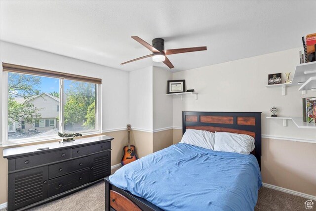 bedroom featuring light colored carpet, baseboards, and ceiling fan