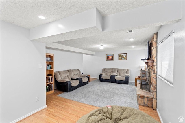 living room with a textured ceiling, wood finished floors, and baseboards