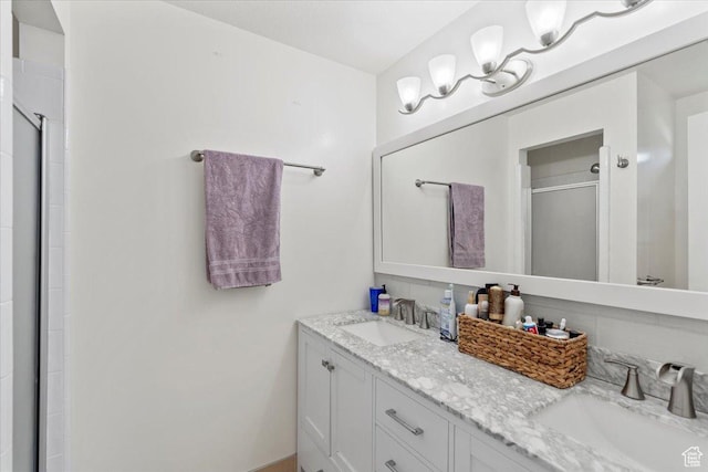 bathroom featuring a stall shower and double vanity