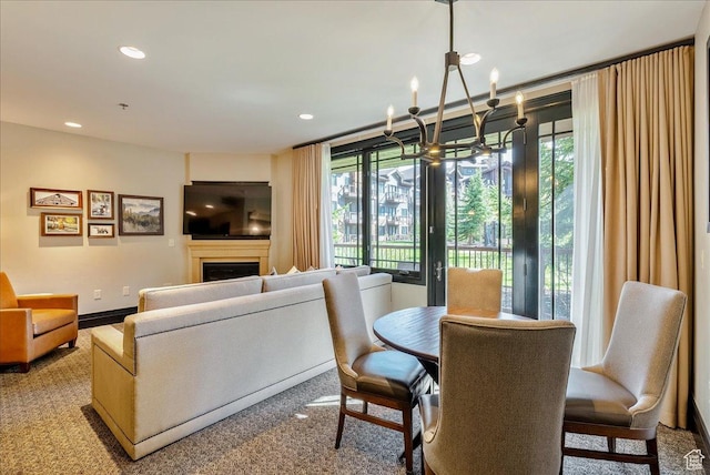 dining room with a chandelier, a fireplace, recessed lighting, and carpet floors