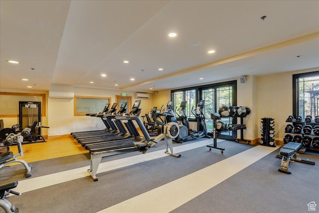 workout area featuring recessed lighting, baseboards, and a wall unit AC